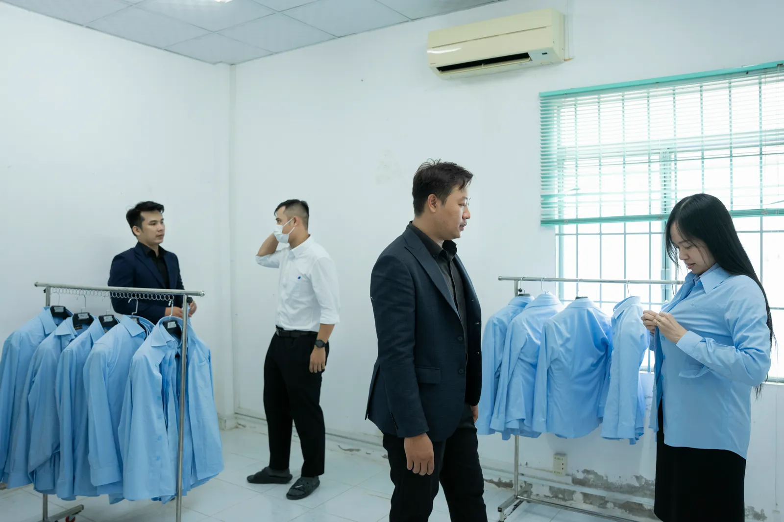 Nhân viên Cấp nước Thủ Đức mặc thử sơ mi mẫu treo trên giá